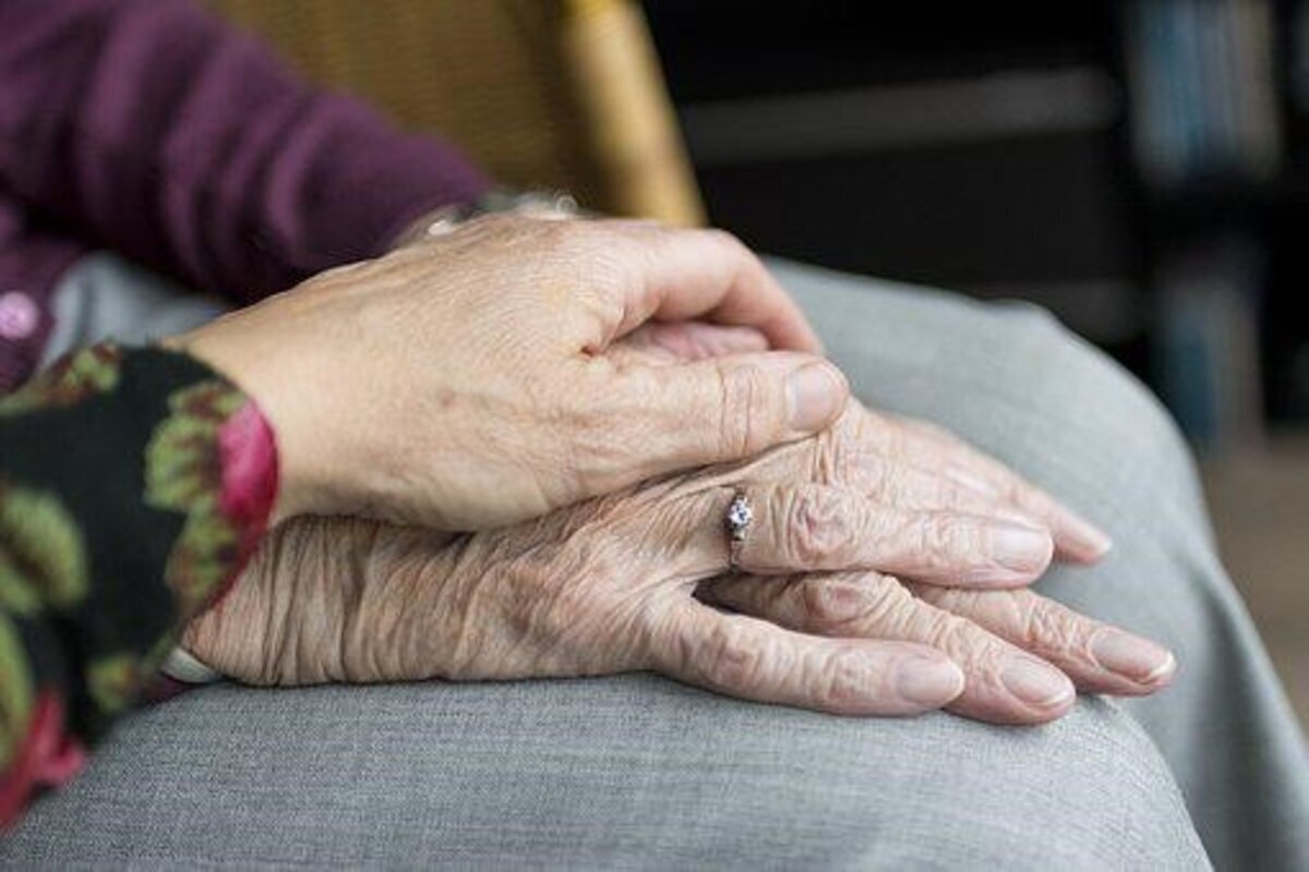 handen van oudere dame met jonger hand