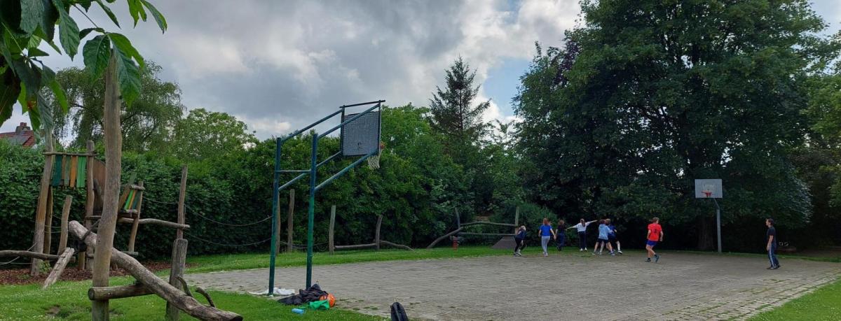 speelpleintje met baskettende jongeren