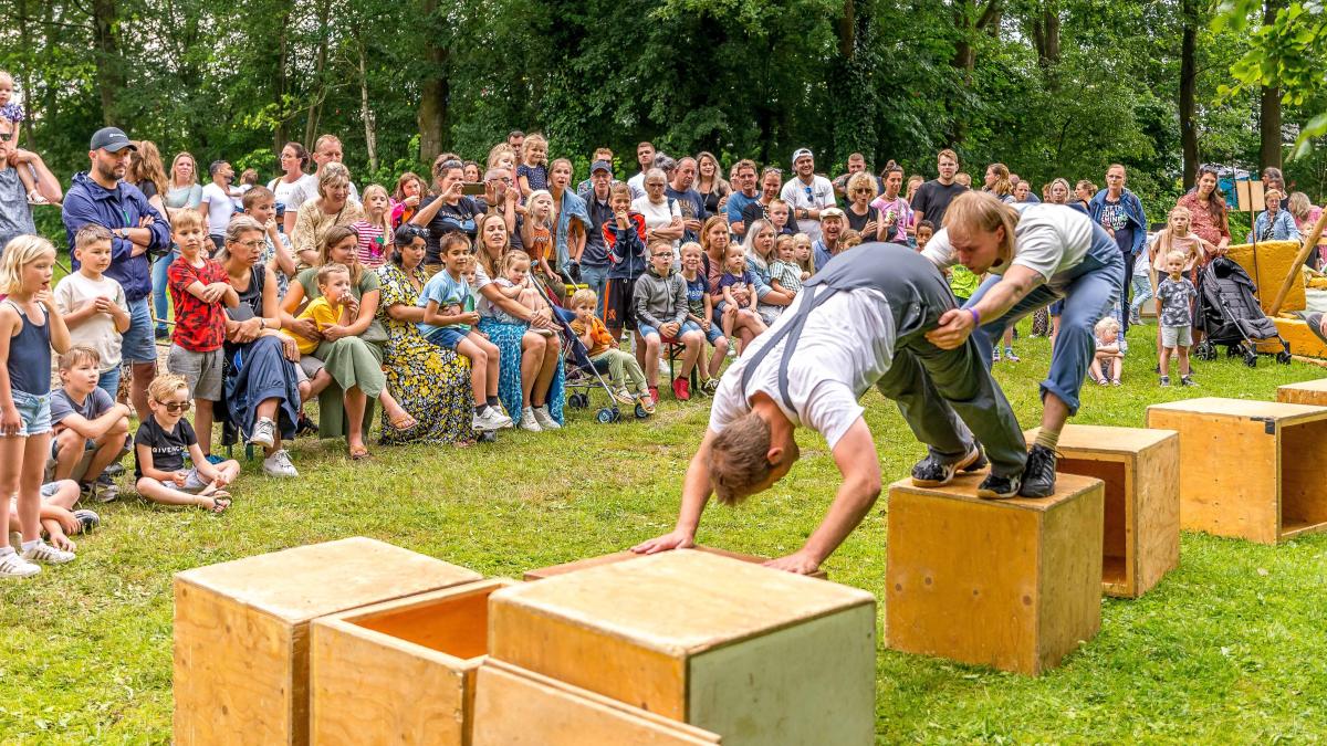 Foto van twee mannen die voor publiek op kratten klauteren