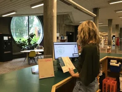 onthaalmedewerker aan balie bibliotheek