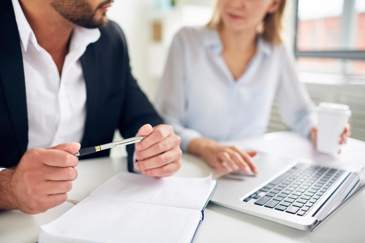 man en vrouw met laptop en papieren