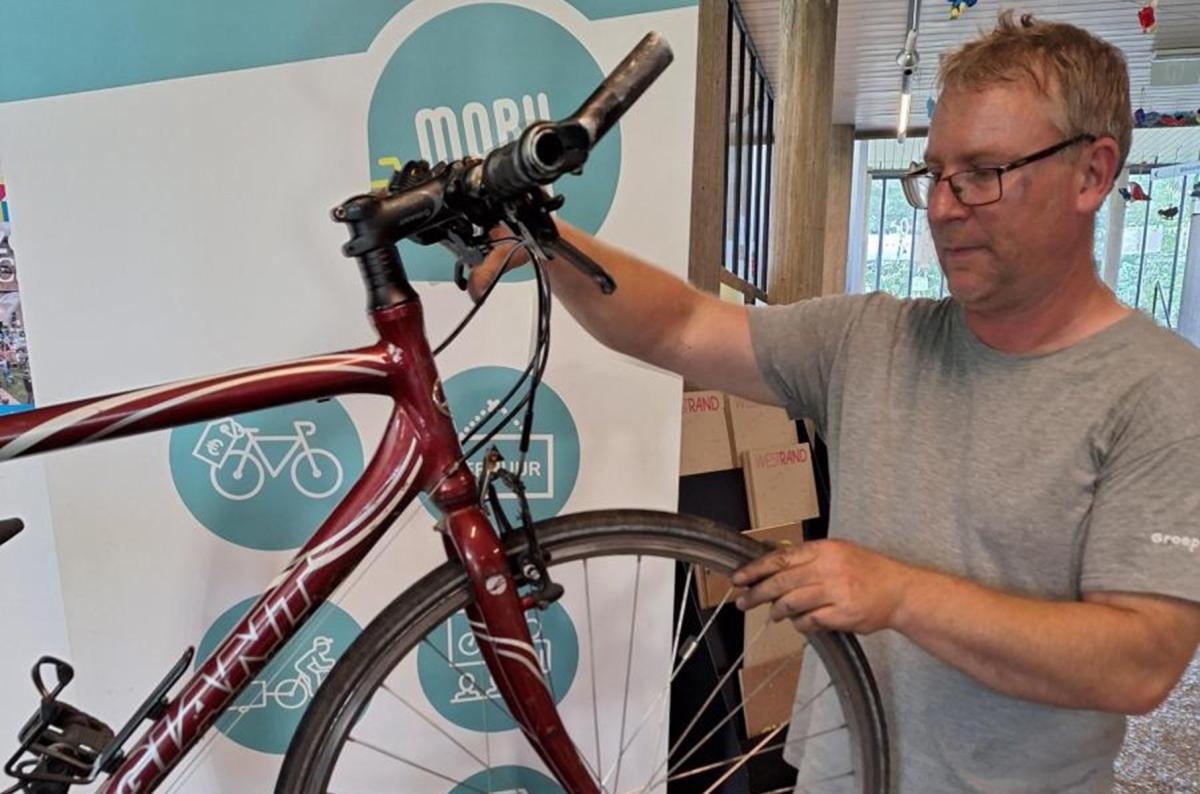 medewerker kijkt een fiets na