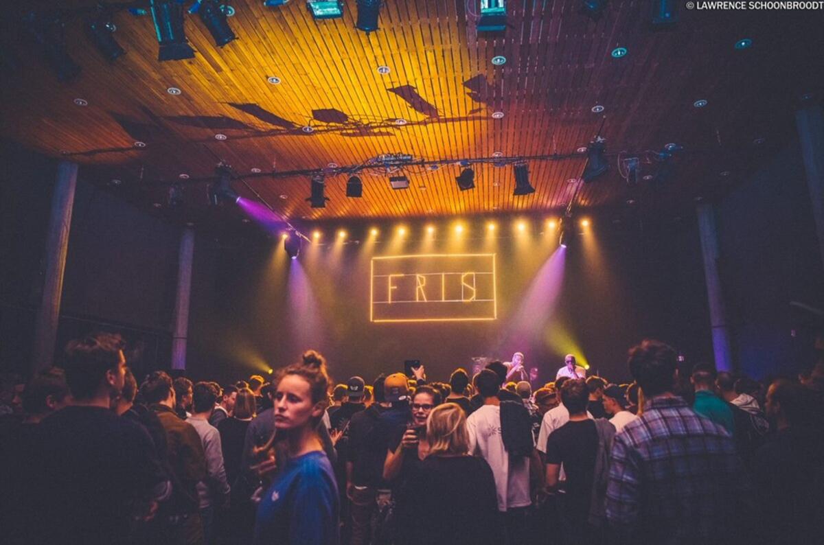 foto van een feestje met het logo van FRIS op de achtergrond