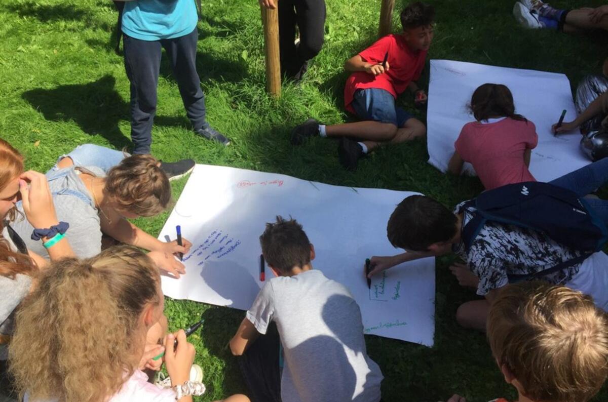 kinderen schrijven op grote bladen