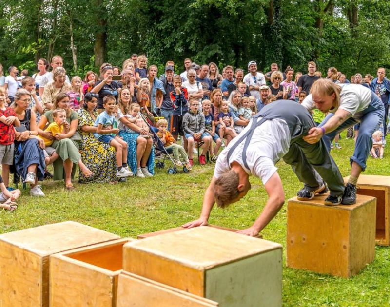 Foto van twee mannen die voor publiek op kratten klauteren