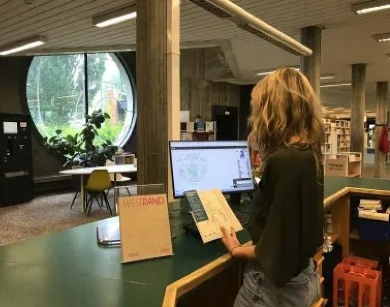 onthaalmedewerker aan balie bibliotheek
