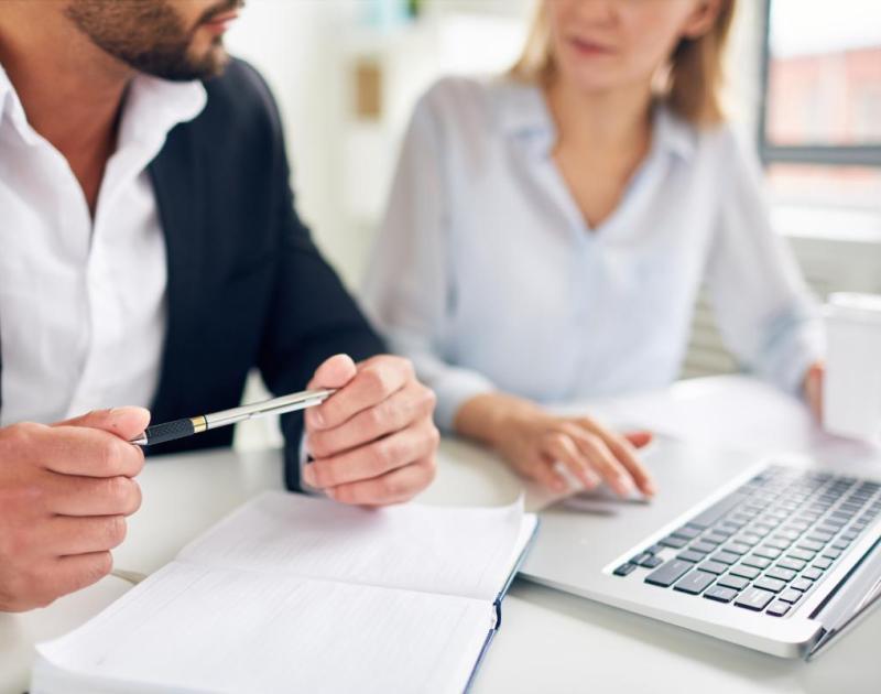man en vrouw met laptop en papieren