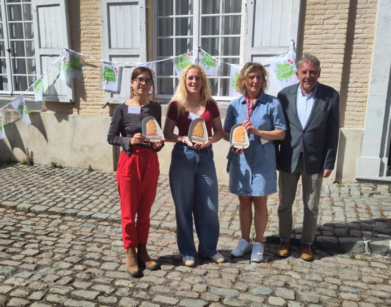 foto van vier mensen op een rij met een trofee