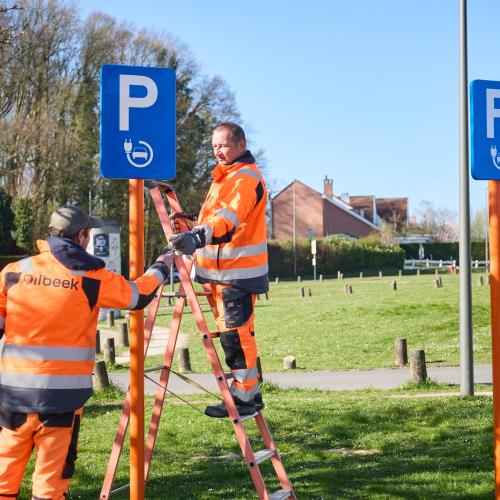 twee werklui die parkeerverkeersbord plaatsen