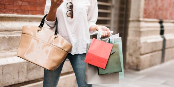 vrouw met smartphone en booschappentassen