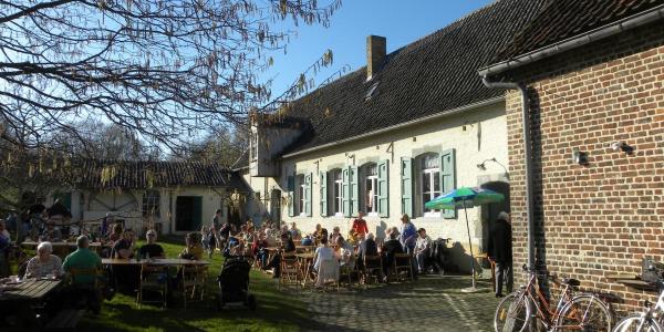 mensen drinken een glas op de binnenkoer van de Pedemolen