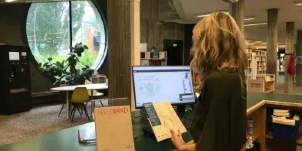onthaalmedewerker aan balie bibliotheek